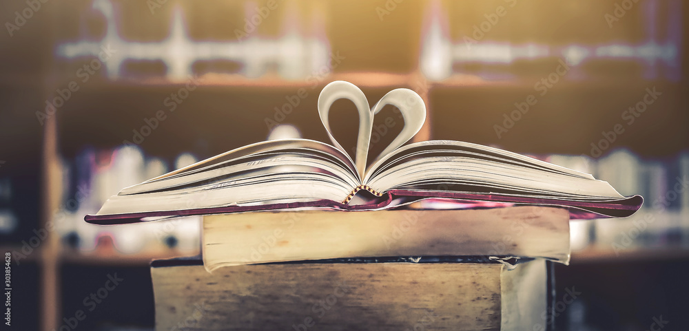 Aufkleber stack of books in the library and blur background