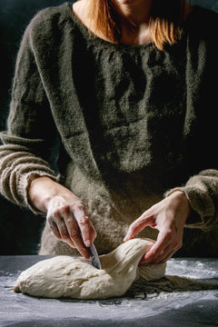 Process Of Making Homemade Bread Dough. Female Hands Splits Dough On Dark Kitchen. Black Table With Flour. Home Bread Baking. Photo Series.