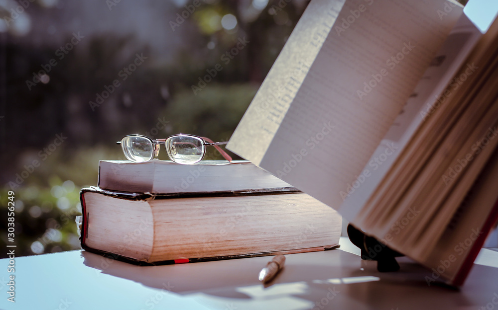 Aufkleber stack of books in the library and blur background