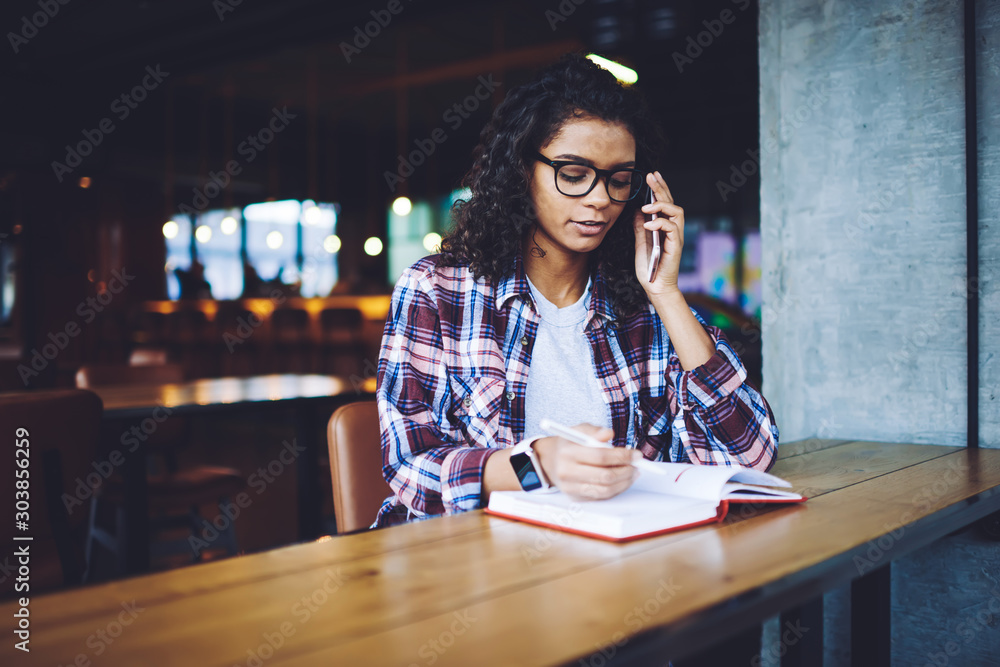 Poster clever dark skinned female student spending time for autodidact and preparing to university examinat