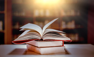 Stack of books in the library and blur bookshelf background