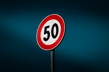 50 miles or kilometers for hour limit. Road sign, urban design, street language, deep blue sky.