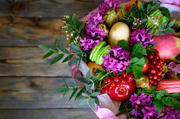 the process of forming a fruit and flower bouquet. tutorial, do it yourself. photo 39,  finished bouquet is in a vase on a wooden background. top view, space for text