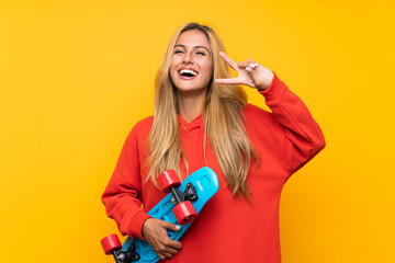 Young skater woman over isolated yellow background