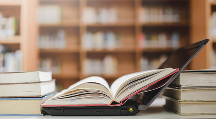 Stack of books in the library and blur bookshelf background