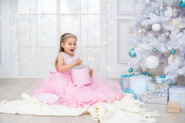 a child in the hall with a big white Christmas tree