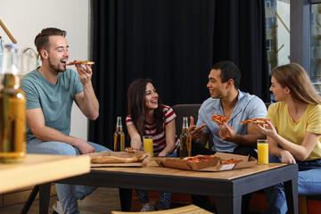 Group of friends having fun party with delicious pizza in cafe