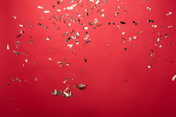 view of golden christmas confetti isolated on red - obrazy, fototapety, plakaty