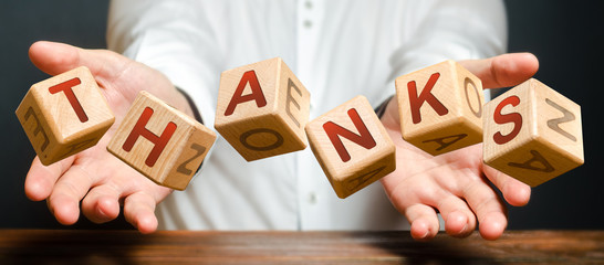 Blocks thrown by a man with letters form the word Thanks. The person brings his thanks and...