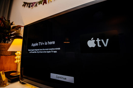 Paris, France - Nov 1, 2019: Side view of Apple TV plus is here message on living room display with try for free continue button launch first day over-the-top ad-free subscription straming service