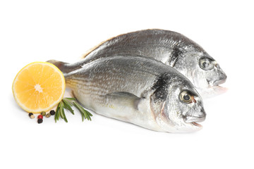 Raw dorada fish with lemon and spices isolated on white