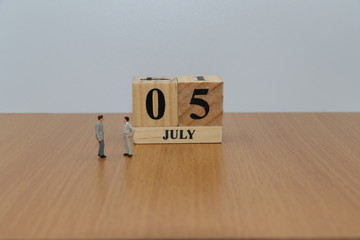 July 5, a calendar photo from the wood The table top consists of a book and pen that is ready to use. White background