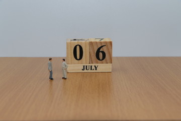 July 6, a calendar photo from the wood The table top consists of a book and pen that is ready to use. White background