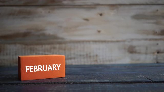 february 19th. Day 19 of month, calendar on a color cubes.  hand puts the day of the month on the name of the month on a wooden background winter, day of the year concept