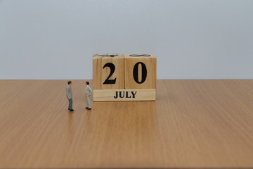 July 20, a calendar photo from the wood The table top consists of a book and pen that is ready to use. White background