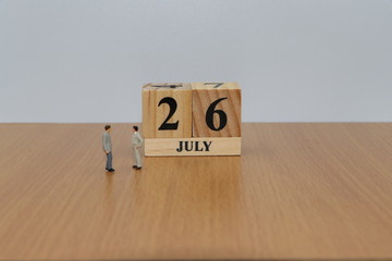 July 26, a calendar photo from the wood The table top consists of a book and pen that is ready to use. White background