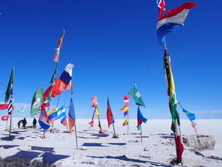 National flags waving in Salar de Uyuni under blue skies, Salar de Uyuni is the world's largest salt flat, Bolivia
