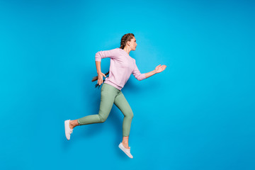 Fototapeta na wymiar Full length profile photo of pretty lady long braids jumping high sports competition run to finish line wear casual pink pullover green pants isolated blue color background