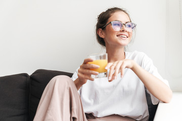 Image of laughing nice woman looking aside and drinking juice