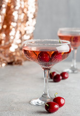 Alcohol sparking drink in champagne glass with cherry