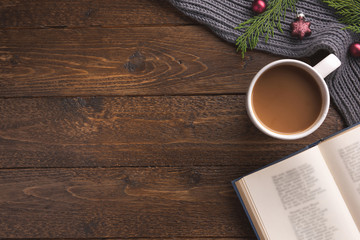 Christmas decoration, book and cup of coffee on wooden background, flat lay. Space for text.