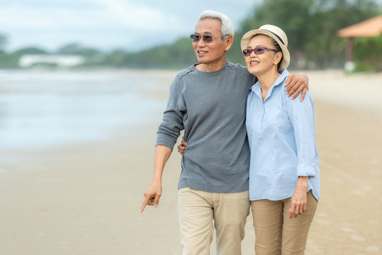 Lifestyle asian senior couple happy walking and relax on the beach.  Tourism elderly family travel leisure and activity after retirement in vacations and summer.