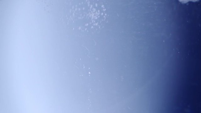 Powerful shot of beady bubbles sparkling into fresh water.