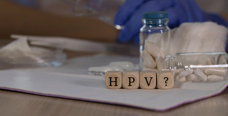 Abbreviation HPV with question mark for human papilloma virus infection composed of wooden dices....