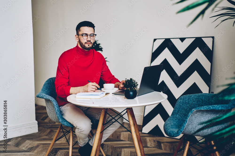 Poster portrait of handsome bearded writer in optical spectacles for vision correction looking at camera wh