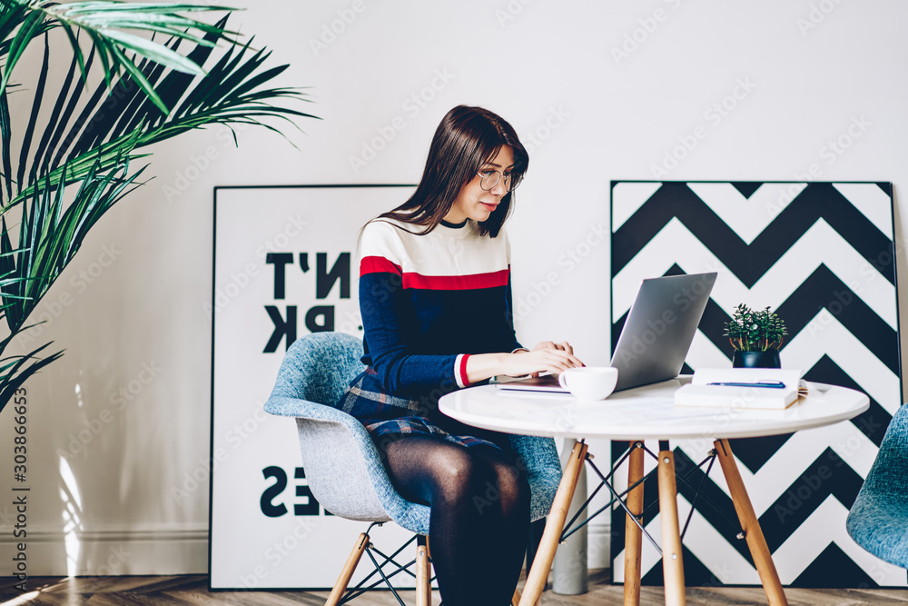 Poster young student in eyeglasses typing information for course work on keyboard of modern laptop device u