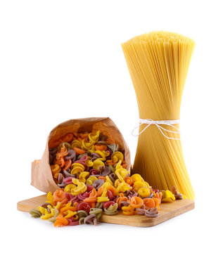 Wooden board with spaghetti and colorful insalatonde pasta isolated on white
