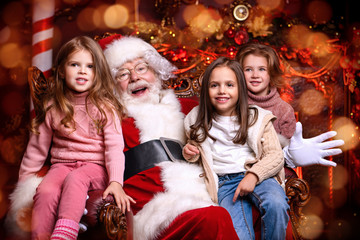 Fototapeta na wymiar happy little girls and Santa Claus