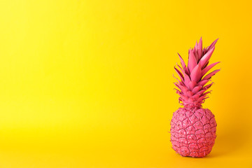 Painted pink pineapple on yellow background, space for text