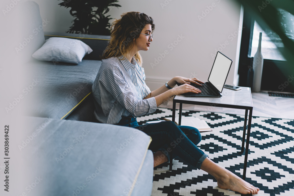Poster pensive young woman keyboarding text on laptop computer and searching information on website for cou