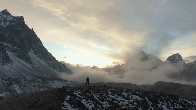 Ama Dablam Mountain and Hiker Man at Sunset. Himalaya, Nepal. Aerial View. Drone is Orbiting