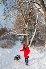Fototapeta na wymiar Portrait of a young woman with dog husky on winter walk.