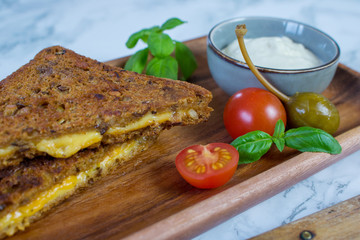Close up food photography of a whole grain bread grilled cheese sandwich on a marble table