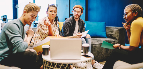 Group of multiracial male and female students watching online webinar on laptop computer studying...