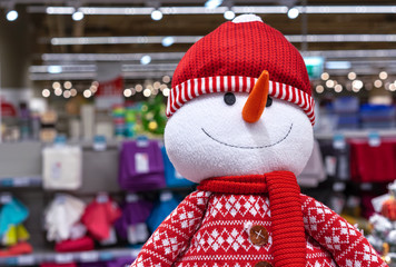 Cristmas soft toy of a snowman in a red sweater, scarf and hat.