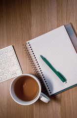 notebook and cup on wooden table