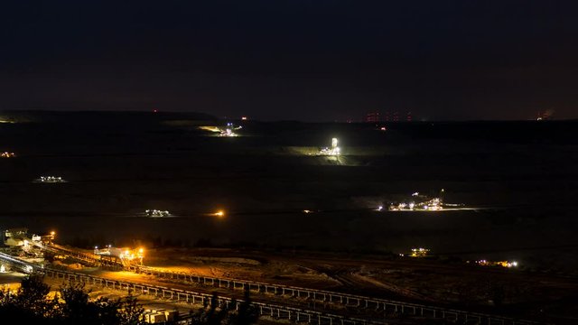 A huge strip mine used for mining lignite. Day-to-Night time lapse zoom in on a stacker used for refilling the already exploited side of the lignite strip mine.