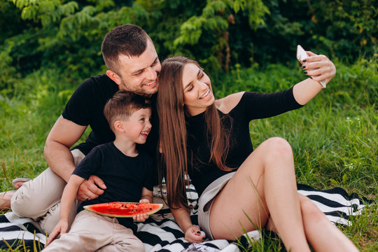 Happy family take a picture selfie during a picnic in the park