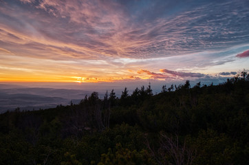 sunrise sun hidden behind clouds in mountains