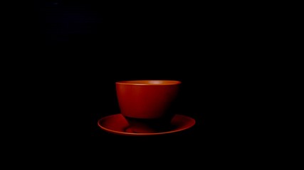 Reddish brown tea cup placed on a black background