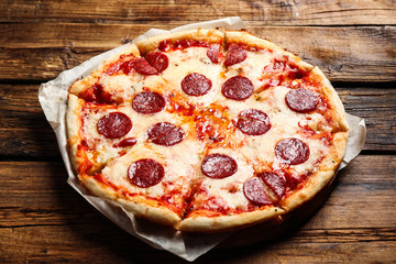 Hot delicious pepperoni pizza on wooden table