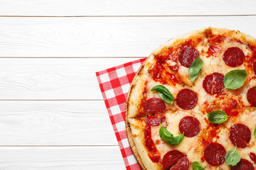 Hot delicious pepperoni pizza on white wooden table, top view. Space for text