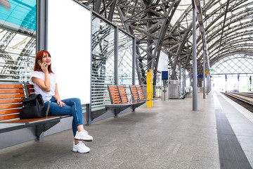 Traveler girl sitting on wooden bench on station