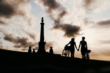 Couple holding hands in a sunset with their bicycles