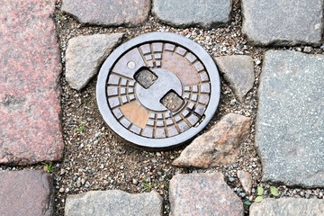 Riga, Latvia, November 2019.Cast-iron manhole of storm sewers as an interesting background. 