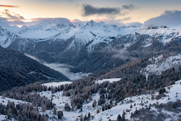 Fototapeta na wymiar Mountain village in Alpine valley during sunrise / Ski resort village getting ready for winter season
